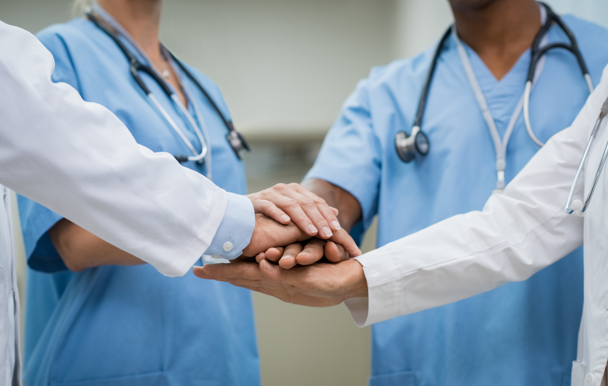 Zdjęcie medyków składających ręce w geście współpracy